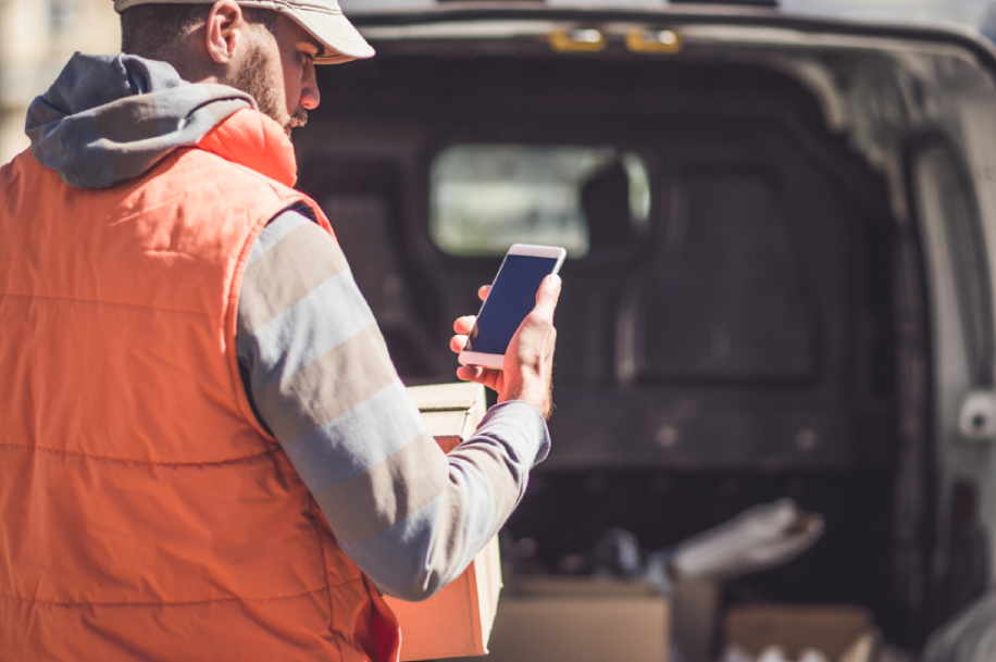 Man checking phone outside van